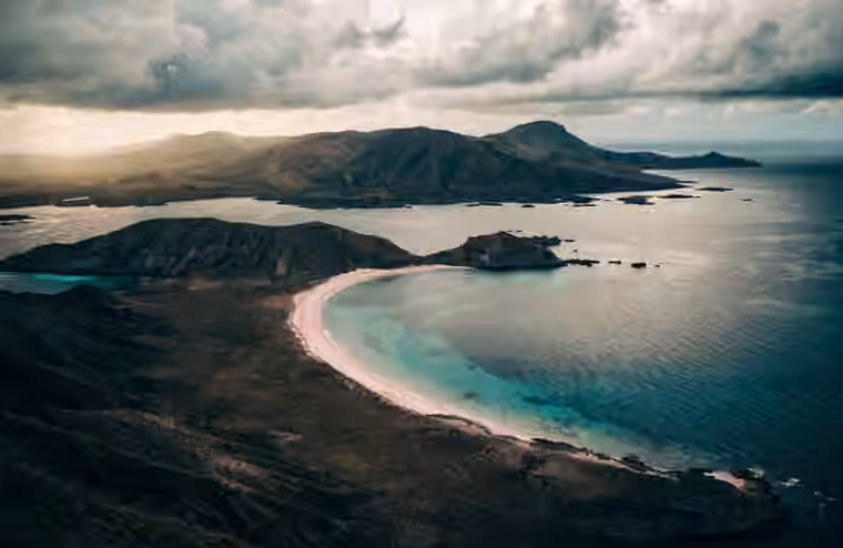The curved pink shoreline and green headlands of Komodo National Park
